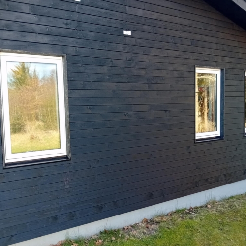 Facade med tre nye hvide vinduer udskiftet af tømrer i hus nær Nykøbing Mors.