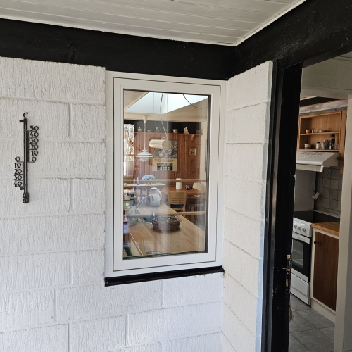 Nyt vindue i hvid karm monteret af tømrer i køkkenhjørne, sommerhus i Nykøbing Mors.