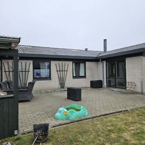Overblik over baggård med flere nye vinduer og terrassedør udskiftet af tømrer i Struer.