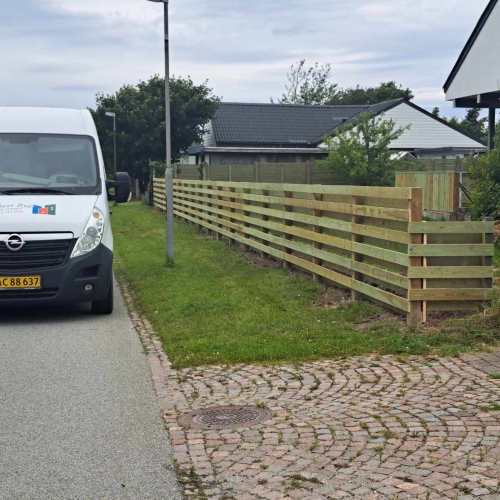 Opsætning af hegn med vandrette brædder langs grund