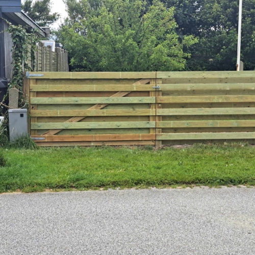 Opsætning af hegn med dobbelt trælåge ved indkørsel