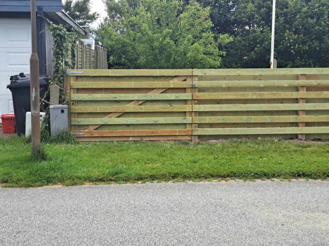 Opsætning af hegn med dobbelt trælåge ved indkørsel