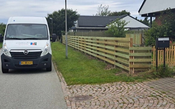 Opsætning af hegn med vandrette brædder langs grund