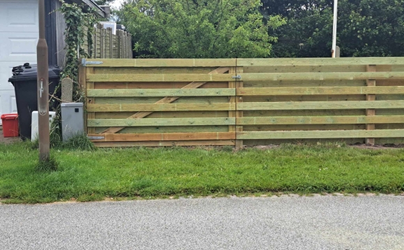 Opsætning af hegn med dobbelt trælåge ved indkørsel
